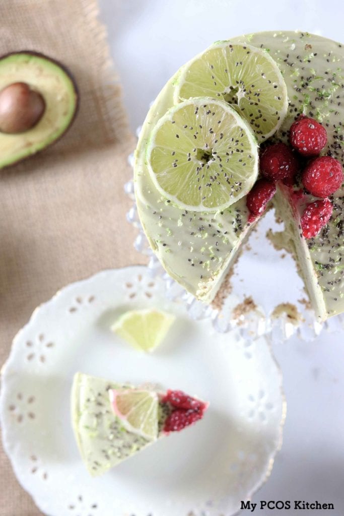 My PCOS Kitchen - Avocado Cheesecake with Lime - An overhead shot of a no bake avocado cheesecake.  Lime slices, raspberries and chia seeds over the cheesecake.