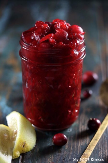 My PCOS Kitchen - Sugar-free Low Carb Cranberry Sauce - Cranberry sauce in mason jar and fresh cranberries with lemon around jar.