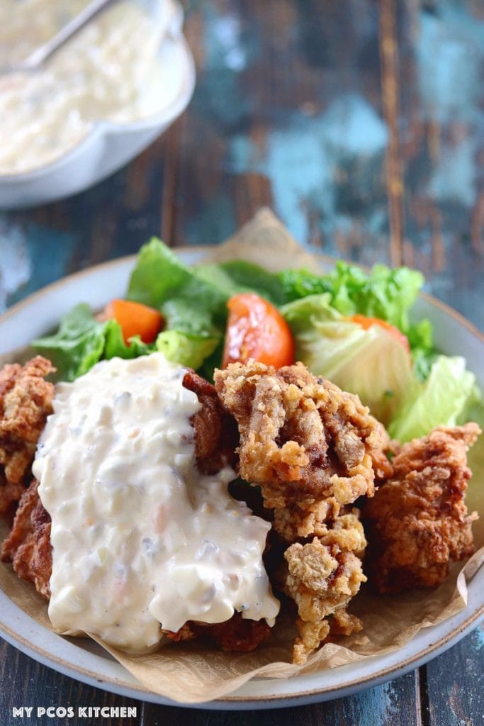 My PCOS Kitchen - Keto Paleo Fried Chicken - Gluten-free, Dairy-free, Grain-free, Pork-Free, Nut-free Fried Chicken - Delicious fried chicken over a blue ceramic plate and covered with dairy-free tartar sauce.