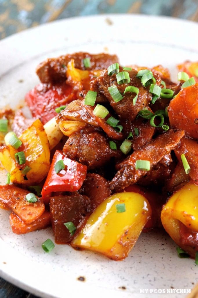 My PCOS Kitchen - Low Carb Paleo Sweet & Sour Pork - A closeup shot of a sugar-free and gluten-free glaze over veggies and fried pork.