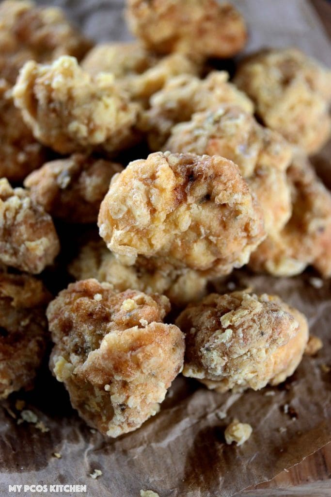 Gluten Free Chicken Nuggets - My PCOS Kitchen - A closeup shot of grain-free chicken nuggets that are also dairy-free. Over a parchment paper that's crumbled up.