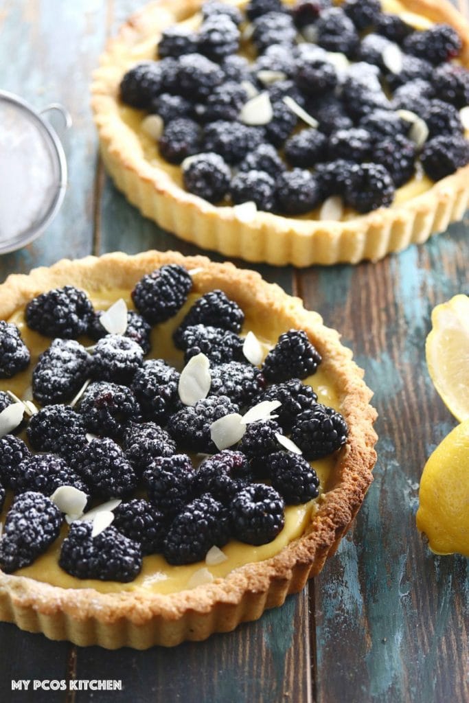 Low Carb Lemon Curd Tart with Blackberries - My PCOS Kitchen - A lemon tart with fresh blackberries and almond slices on top.