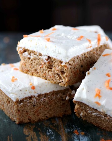 Sugar Free Carrot Cake - My PCOS Kitchen - Square carrot cake bars piled on top of another with some sugar free cream cheese frosting.