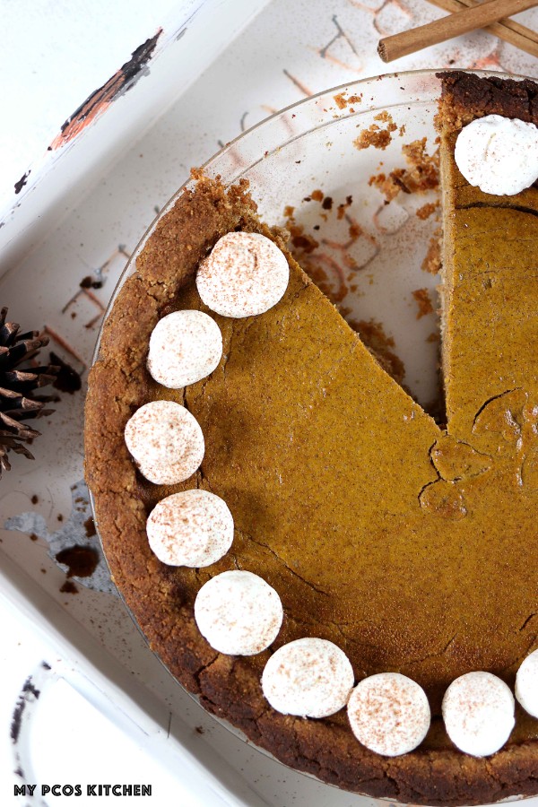 A slice missing out of a round paleo pumpkin pie.