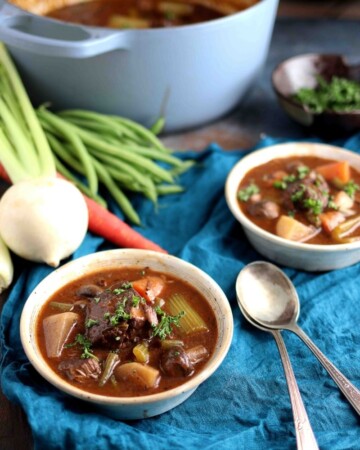 Two bowls of gluten free beef stew filled with hearty vegetables.