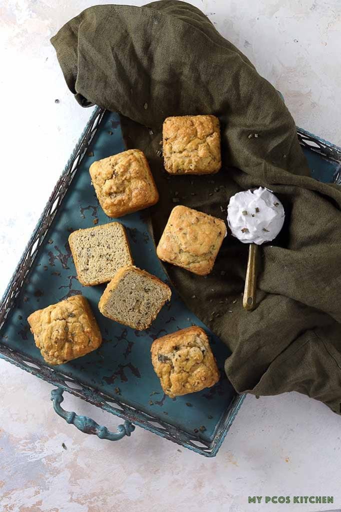Dairy free biscuits on a blue tray over a green linen and a cup of coconut cream.