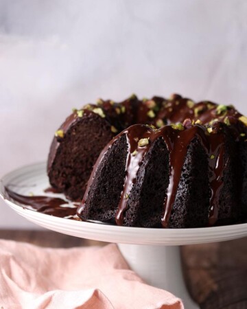 A dairy free keto chocolate cake made in a bundt mold covered in sugar free chocolate.