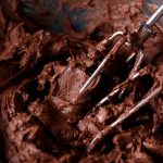 A bowl full of low carb chocolate frosting made with a hand mixer.