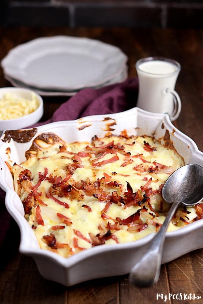 Cauliflower au gratin topped with melted cheese and bacon on top of a baking dish ready to be served.
